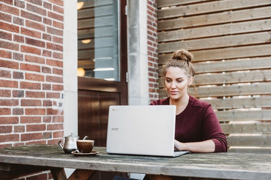 Frau arbeitet im Freien mit Laptop – passend zur digitalen Vereinsverwaltung
