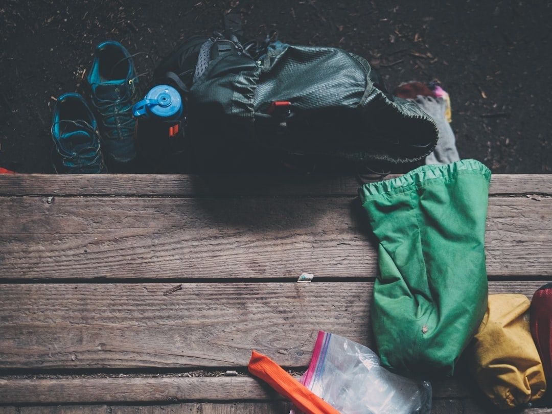 Outdoor-Rucksack, Schuhe und Funktionskleidung auf einer Holzbank